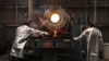 A worker takes a sample for testing as molten gold is poured into bars at the Akara Resources' Chatree gold mine in Thailand's Phichit province, March 23, 2023.