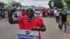 Dans la capitale Abuja, des centaines de manifestants défilaient dans la ville en brandissant des pancartes telles que "laissez les pauvres respirer".