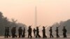 With the Washington Monument in the background and a thick layer of smoke, Marine Corps honor color guard rehearse, June 8, 2023, in Washington.