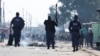 Des policiers sud-africains réagissent lors de la grève en cours des opérateurs de taxi contre les autorités chargées de la circulation au Cap, en Afrique du Sud, le 7 août 2023.
