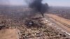 This image grab taken from AFPTV video footage on April 20, 2023, shows an aerial view of black smoke rising above the Khartoum International Airport amid ongoing battles between the forces of two rival generals.