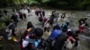 FILE - Migrants, mostly Venezuelans, cross a river during their journey through the Darien Gap from Colombia into Panama, hoping to reach the US, Oct. 15, 2022. 