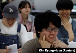 Siswa berlatih tersenyum pada kursus pelatihan senyum di Sekolah Seni Sokei di Tokyo, Jepang, 30 Mei 2023. (Foto: REUTERS/Kim Kyung-Hoon)