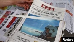 北京街头报摊上的报纸头版展示中国空军参加在台湾周边海空领域进行军演的照片。（2022年8月8日）（路透社）