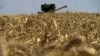 FILE - This July 31, 2022, photo shows a grain combine harvester collecting wheat near Novoazovsk outside Mariupol, amid the ongoing Russian military action in Ukraine. 