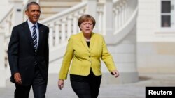 German Chancellor Angela Merkel and U.S. President Barack Obama walk to inspect the guard of honour during a welcoming ceremony at Schloss Herrenhausen in Hanover, Germany, April 24, 2016. 