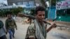 FILE - Fighters loyal to the Tigray People's Liberation Front walk along a street in the town of Hawzen, then controlled by the group, in the Tigray region of northern Ethiopia, May 7, 2021. 