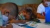 Los niños asisten a clase en un aula improvisada en una casa en el barrio de Petare, el barrio marginal más grande de Venezuela, en Caracas en medio de la pandemia del nuevo coronavirus COVID-19, el 16 de septiembre de 2020.