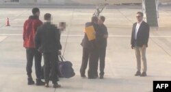 This video grab taken from a footage shown by Russian state media purports to show U.S. basketball star Brittney Griner, left, during a prisoner swap with Viktor Bout, a notorious Russian arms dealer, second-right, on the tarmac of Abu Dhabi airport, Dec. 8, 2022.
