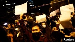 北京民众走上街头举起白纸游行抗议当局严厉的防疫封控措施。（2022年11月27日）