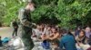 (မှတ်တမ်း ပုံဟောင်း) In this photo released by the Royal Thai Navy taken June 4, 2022, members of the Thai navy help Rohingya refugees found on Koh Dong Island in Satun province, southern Thailand.