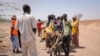 Les gens traversent la frontière du Soudan au Soudan du Sud sur une charrette à âne et s'enregistrent auprès du personnel de surveillance des frontières, au poste frontière de Joda au Soudan du Sud le mardi 16 mai 2023.