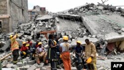 Des sauveteurs font une pause sur les lieux d'un bâtiment effondré, imputé à de mauvais matériaux de construction à Kirigiti, dans le comté de Kiambu, le 26 septembre 2022.