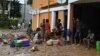 Des personnes se tiennent devant leurs maisons inondées à Bingerville, près d'Abidjan, le 21 juin 2022.