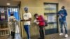 People who were just tested for COVID-19 wait in line to make payment for the test at a private laboratory in Johannesburg, South Africa, Dec. 19, 2020.