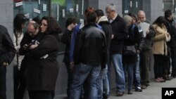 Españoles hacen fila en busca de trabajo en una oficina de empleos en Madrid.