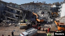 Emergency personnel work at the site of damaged buildings after an earthquake in Elazig, Turkey, Jan. 27, 2020. 