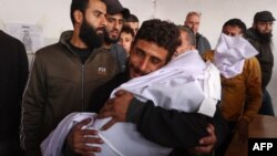Um homem chora enquanto segura o corpo de uma criança de dois anos que foi morta por estilhaços na sequência de um ataque israelita na Cidade de Gaza, no hospital árabe Al-Ahli, a 5 de dezembro de 2024