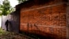 Archivo - En esta foto del 10 de octubre de 2019, un policía hace guardia al lado de un graffiti con el nombre de una pandilla como parte de la patrulla rutinaria en Lourdes, La Libertad, El Salvador.