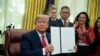 President Donald Trump shows an executive order establishing the Task Force on Missing and Murdered American Indians and Alaska Natives, in the Oval Office of the White House, Tuesday, Nov. 26, 2019, in Washington. (AP Photo/ Evan Vucci)