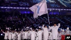 南北韓運動員星期五，在一面藍白相間象徵朝鮮統一旗幟的引領下進場。