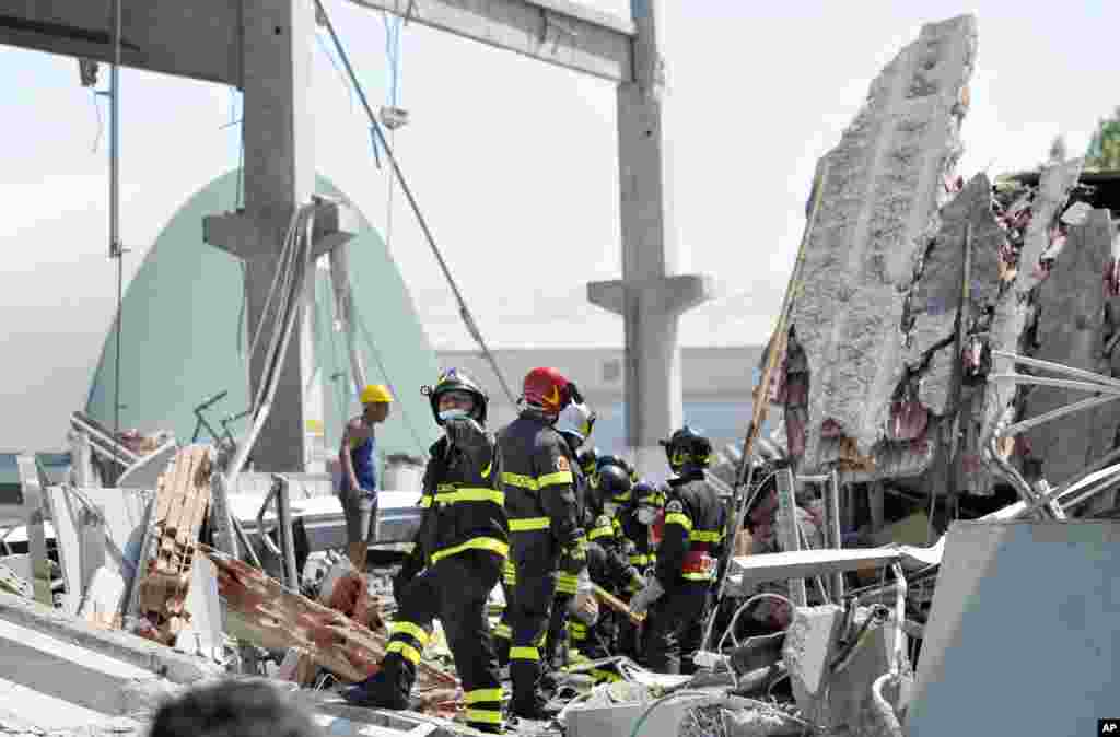 Bomberos italianos trabajan entre los escombros de una fábrica derrumbada por el terremoto en Mirandola, en el norte de Italia este martes 29 de mayo de 2009.