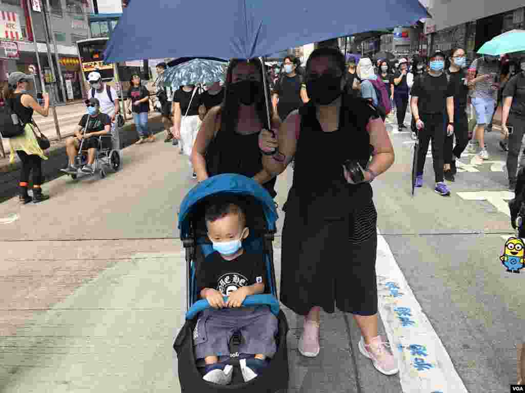 有家長帶同年幼兒子一同戴上口罩參與10月5日”全民蒙面遊行”，反對當局實施”禁蒙面法” (美國之音湯惠芸拍攝)