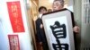 台北銅鑼灣書店創辦人林榮基手持台灣公民參與協會理事長何宗勳寫的“自由”字畫。