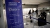 一名乘客在英國航空公司的櫃檯前整理行李。