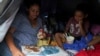 Madre solicitante de asilo de El Salvador le lee a su hijo de cuatro años en una tienda de campaña donde viven después de ser enviados de regreso bajo los Protocolos de Protección al Migrante (MPP) en Matamoros, México el 30 de octubre de 2019.