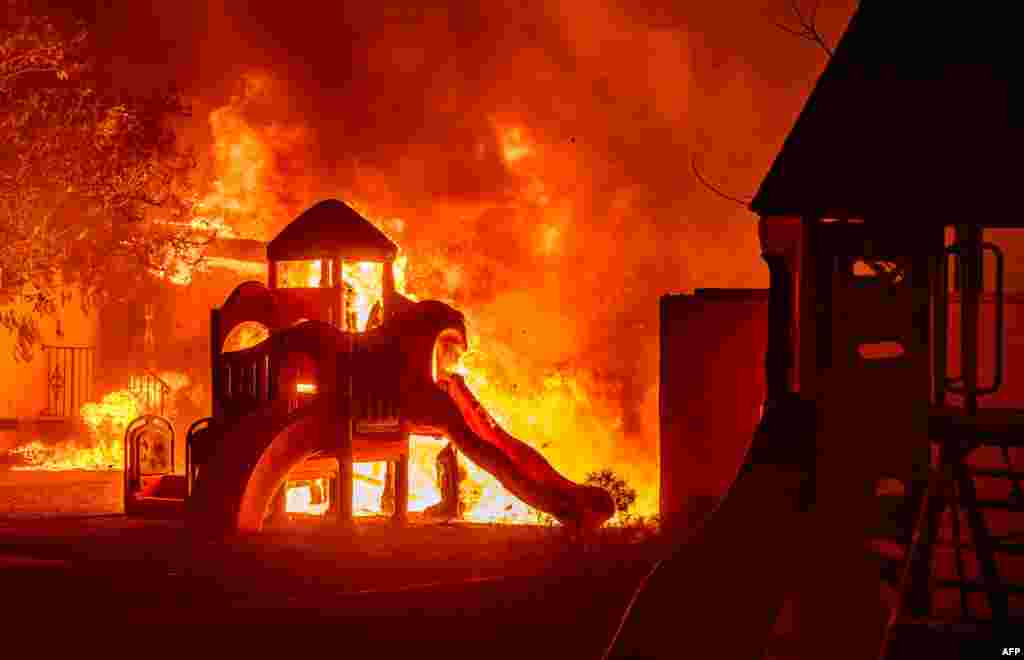Um parque infantil pega fogo num bairro residencial durante o incêndio de Eaton, em Pasadena, Califórnia, a 7 de janeiro de 2025.