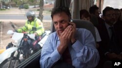 El senador brasileño Aécio Neves habla en su celular desde el microbus en el que intentaron visitar a los lideres opositores venezolanos presos.