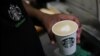 An employee prepares a coffee drink at a Starbucks' outlet at a market in New Delhi