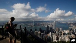 一名遊客在香港島太平山頂俯瞰維多利亞港景色。(資料圖片)