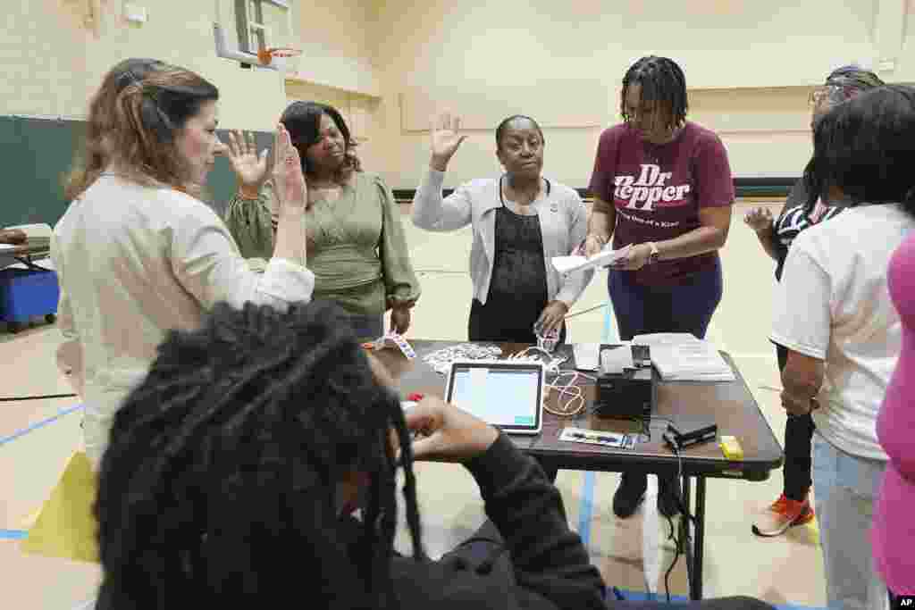 Funcionários eleitorais em &nbsp;North Jackson, Mississippi, recitam o seu juramento de posse antes de abrirem o local para os eleitores de manhã cedo, a 5 de novembro de 2024.