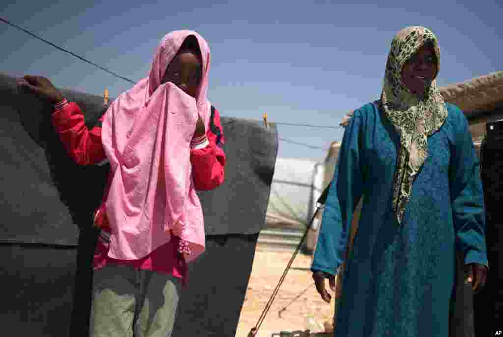 Syrian refugee Omm Mohammed, 33, right, and her daughter, stand in front of their family tent at Zaatari Syrian refugee camp, in Mafraq, Jordan, August 28, 2013. 