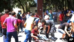 Gente ayudando a los heridos tras la explosión en Suruc, Turquía, el lunes, 20 de julio de 2015.