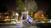 FILE - An Israeli peace activist hands out signs prior to a protest in Tel Aviv, Israel, Jan. 15, 2011. A newly-proposed Israeli law would require nonprofit groups to wear badges identifying foreign sources of funding.