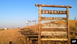 FILE - This Sept. 9, 2012 file photo shows the entrance to the Pine Ridge Indian Reservation in South Dakota, home to the Oglala Lakota tribe. (AP Photo/Kristi Eaton)