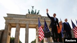 Antes de su discurso el presidente Obama saludó a la multitud frente a la histórica puerta de Brandeburgo, acompañado por la canciller alemana Angela Merkel y el alcalde de Berlín, Klaus Wowereit.