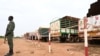 Un policier nigérien monte la garde à côté de quelques-uns des 300 camions principalement chargés de nourriture arrivés du Burkina Faso, à Niamey, le 21 août 2023.