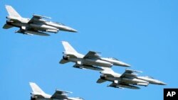 Американські винищувачі F-16 у небі над Варшавою під час великого військового параду на честь Дня Війська Польського в пам'ять про битву 1920 року, в якій польські війська перемогли наступаючі більшовицькі сили, у Варшаві, Польща, у вівторок , 15 серпня 2023 року.