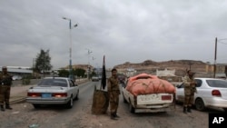 Soldados yemeníes inspeccionaban los autos en un puesto de control en la ruta que conduce a la embajada de Estados Unidos en Sanaa, Yemen.