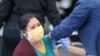 Una mujer recibe una vacuna contra la enfermedad por coronavirus (COVID-19), en Jordan Downs en Los Ángeles, California, EE. UU., 10 de marzo de 2021.