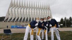 Frente a la capilla de la Academia de la Fuerza Aérea de EE.UU., cadetes con máscaras faciales posan para los fotógrafos después de su ceremonia de graduación. Sábado 18 de abril de 2020, Colorado Springs, Colorado.