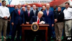 El Presidente Donald Trump firma una orden ejecutiva sobre el establecimiento de la Oficina de Políticas de Comercio y Manufactura. Lo hizo junto con el vicepresidente Mike Pence; el secretario de Asuntos de Veteranos, David Shulkin; y el secretario de Comercio de Estados Unidos, Wilbur Ross. Harrisburg, Pensilvania, sábado 29 de abril de 2017.