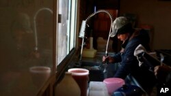 Un migrante recientemente deportado de Estados Unidos lava platos después de comer en un refugio de migrantes en Ciudad Juárez, México, el miércoles 25 de enero de 2017.