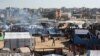 Palestinianos aguardam por uma porção de alimentos num centro de distribuição a sul de Khan Yunis, no sul da Faixa de Gaza, a 17 de dezembro de 2024, no meio da guerra em curso entre Israel e o movimento palestiniano Hamas.