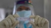 Un trabajador de la salud muestra un resultado positivo de COVID-19 durante una prueba aleatoria para los familiares del personal del ejército en el hospital de la base del ejército en Gauhati, India, el lunes 19 de octubre de 2020.