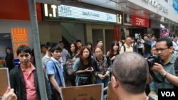 有大陸遊客在旺角街頭駐足圍觀示威者呼籲旅客不要隨地便溺的標語